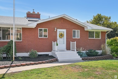 View of front of house featuring brick siding, a front yard, and a chimney
