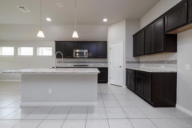 Kitchen featuring stainless steel microwave, back