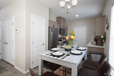 Kitchen featuring an inviting chandelier, light countertops, appliances with stainless steel finishes, gray cabinets, and backsplash