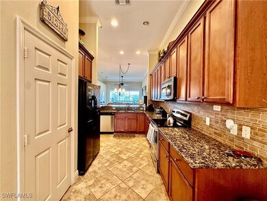 Kitchen featuring dark stone countertops, applianc