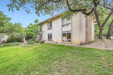 Back of property featuring a lawn and brick siding