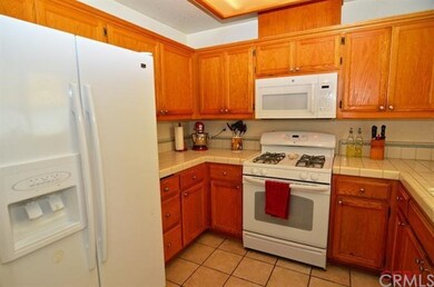 The kitchen has tile floors and counter tops and l