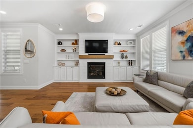 Living room with baseboards, a large fireplace, vi