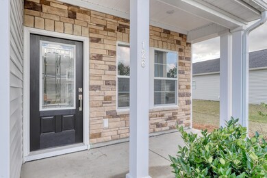 View of exterior entry featuring covered porch and