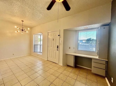 Foyer featuring a textured ceiling, light tile pa