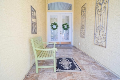 Entrance to property with stucco siding and french doors