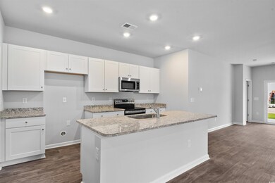 Kitchen with a center island with sink, white cabi