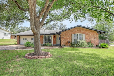 Single story home with brick siding, a garage, co