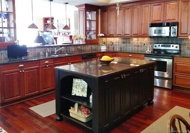 Kitchen features custom cherry cabinets and granit