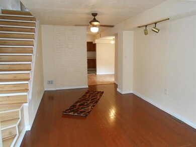 Living room with hardwood and exposed brick.