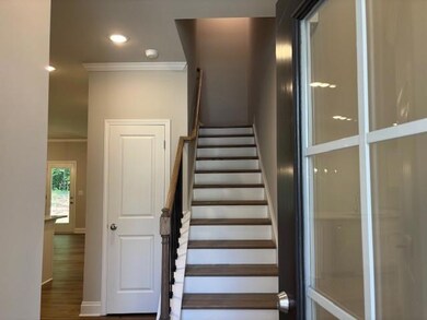 Welcoming entry with hardwood stairs
