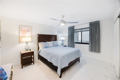 Bedroom with marble look tile flooring, a closet, and a ceiling fan