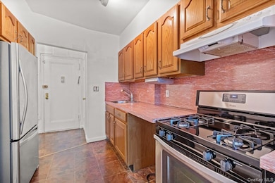 Kitchen featurning oak cabinetry and  stainless steel appliances.