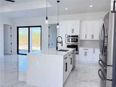 Kitchen featuring light stone countertops, applian