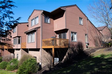 Back faces mature trees with three decks including