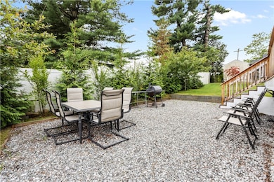 Gravel paitio area with back fencing and privacy plantings!