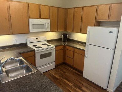 Kitchen featuring dark countertops, dark wood fini