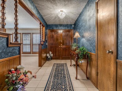 Entrance foyer with a chandelier, light tile patte