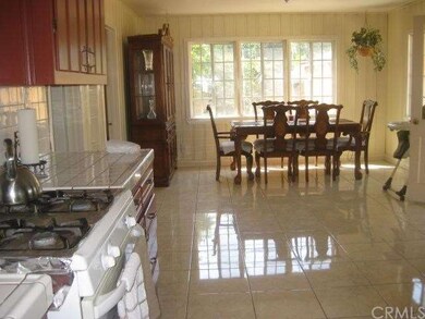 View of the kitchen with the dining area beyond.  