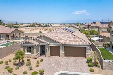 View of front of property with a mountain view, stucco siding, stone siding, decorative driveway, and a garage