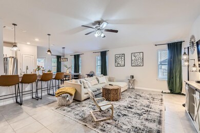Living room with light tile patterned flooring, a ceiling fan, and recessed lighting