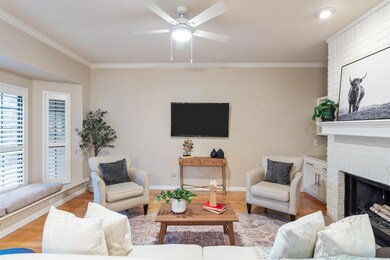 Living area featuring crown molding, a ceiling fa