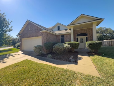 View of front of house featuring driveway, brick siding, and an attached garage