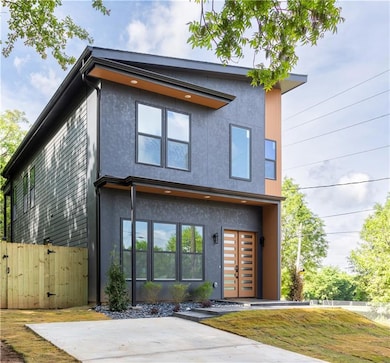 Modern home with fence and stucco siding