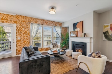 Sitting room featuring hardwood / wood-style flooring, a glass covered fireplace, and wallpapered walls