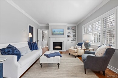Living room with light hardwood / wood-style floors, ornamental molding, and built in shelves