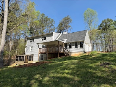 Back of property with a sunroom, a yard, a shingled roof, and a chimney