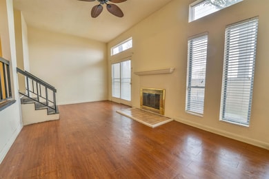 Unfurnished living room with stairs, a tiled firep
