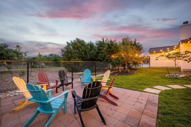 Patio terrace at dusk featuring a fire pit, fence
