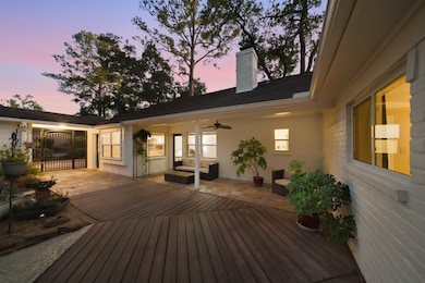 Discover a spacious patio with stylish decking and versatile seating areas, designed for relaxing or hosting gatherings in a private outdoor setting. Lush plants, easy access to the home, and the detached garage create an ideal extension of your indoor living space.