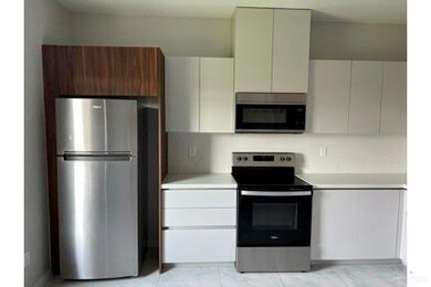 Kitchen featuring appliances with stainless steel finishes, light countertops, modern cabinets, and light marble finish flooring
