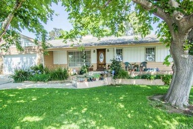 Front of home with shaded front lawn, lovely garde