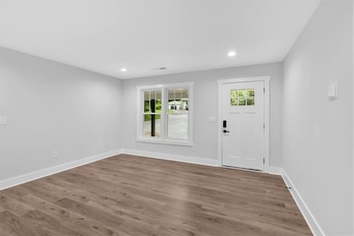 Entryway featuring wood finished floors, baseboards, and recessed lighting