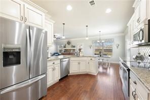 Kitchen with decorative light fixtures, a peninsul