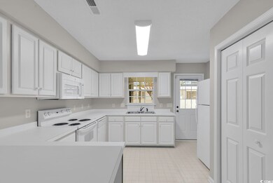 Kitchen featuring sink, white cabinets, and white 