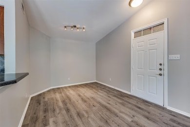Foyer entrance with wood finished floors and baseboards