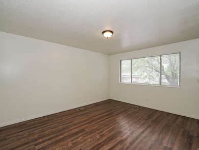 Spare room featuring a textured ceiling and wood finished floors