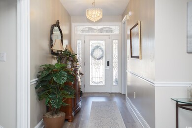 Entryway with dark wood-type flooring and a chande
