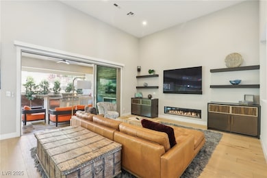 Living area featuring a glass fireplace, ceiling f