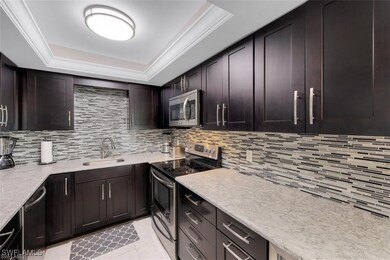 Kitchen with a sink, a raised ceiling, decorative