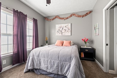 Carpeted bedroom featuring a textured ceiling and ceiling fan