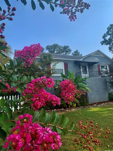 Shade trees surround cute home w/burgundy shutters