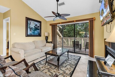 Living area featuring vaulted ceiling, a ceiling fan, light tile patterned floors, a fireplace, and baseboards