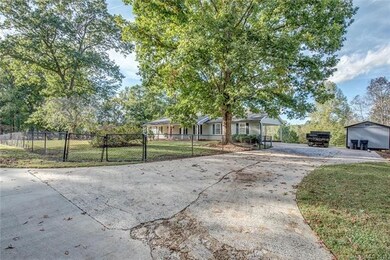 Driveway with side entry carport. Extra parking and storage building.