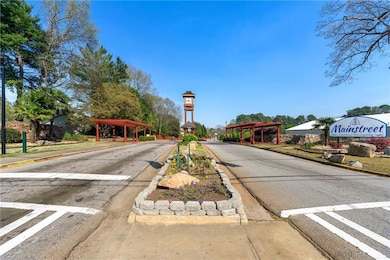 View of asphalt road featuring curbs, sidewalks, and street lights