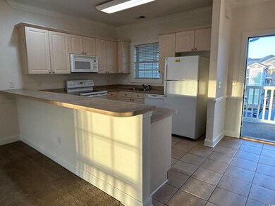 Kitchen featuring ornamental molding, white applia